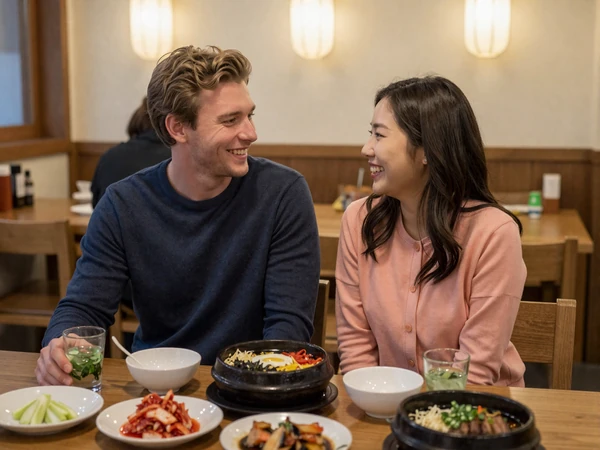 Happy cross-cultural couple enjoying Korean cuisine together at a cozy restaurant with bibimbap and kimchi