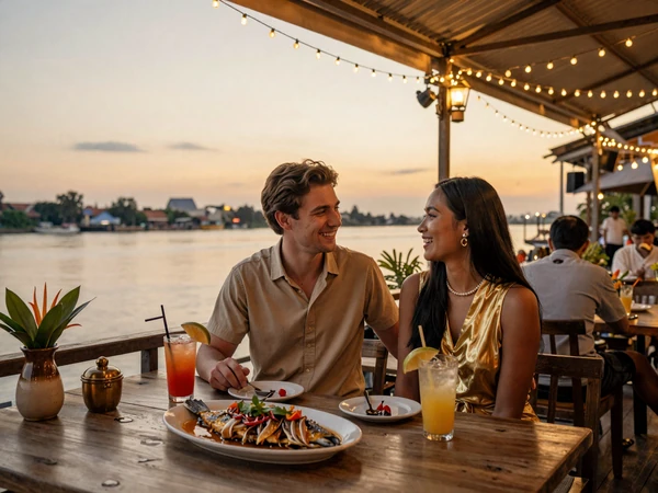 Happy cross-cultural couple enjoying Cambodian cuisine at a riverside restaurant in Phnom Penh with Mekong River view